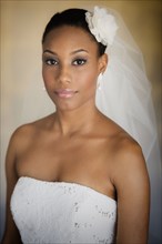 Mixed race bride wearing wedding gown and veil