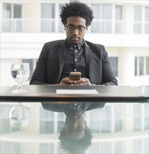 Hispanic businessman using cell phone at conference table