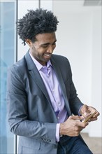 Hispanic businessman using cell phone in office
