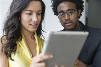 Hispanic business people using digital tablet