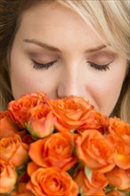 Caucasian woman smelling bouquet of flowers