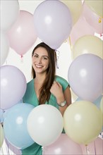 Hispanic woman standing with balloons