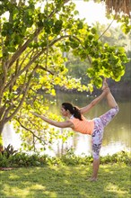Hispanic woman practicing yoga in park
