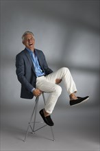 Caucasian businessman laughing on stool