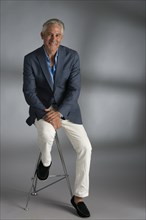 Caucasian businessman smiling on stool