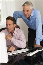 Caucasian businessmen working at computer