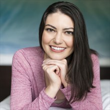 Hispanic woman resting chin in hands