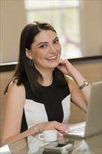 Hispanic businesswoman smiling in office