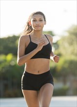Mixed race teenage girl running outdoors