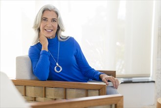 Caucasian woman smiling in armchair