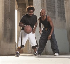 African father playing basketball with son