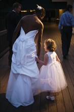 Bride and flower girl holding hands