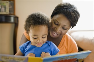 African mother reading to young son