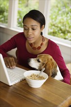 African woman with dog looking at laptop