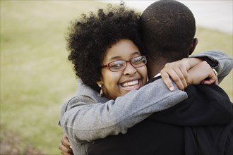 Smiling mixed race woman hugging boyfriend