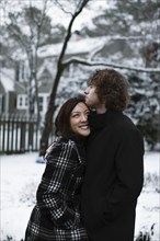 Couple hugging outdoors in snow