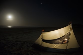 Caucasian man camping on beach