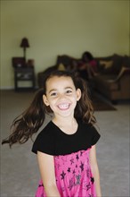 Grinning mixed race girl in living room