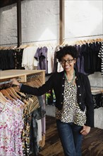 Mixed race woman working in clothing store