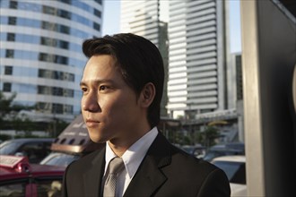 Serious Asian businessman outdoors