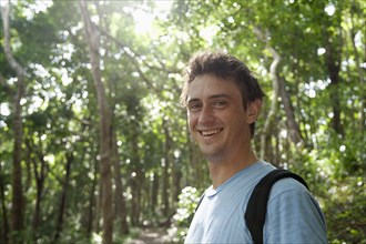 Smiling Caucasian man standing in forest