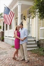 Caucasian couple hugging near porch