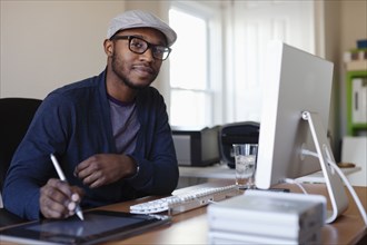 Black designer working at desk