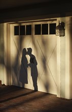 Shadow on garage of couple kissing