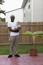 Father holding baby outdoors