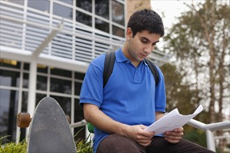 Middle Eastern student reading notes on campus
