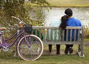 Student couple sitting on park bench