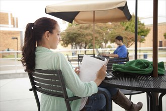 Students studying at tables on campus