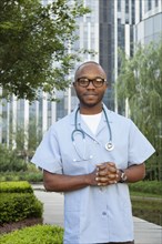 Black doctor smiling in urban park