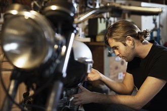 Caucasian mechanic working on motorcycle