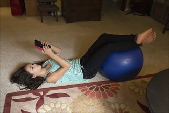 Mixed race girl using digital tablet on floor