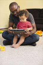 Father and toddler son using digital tablet