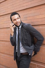 Mixed race businessman talking on cell phone outdoors