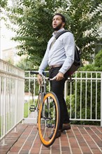Mixed race businessman with bicycle on front stoop