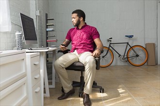 Mixed race businessman sitting at desk