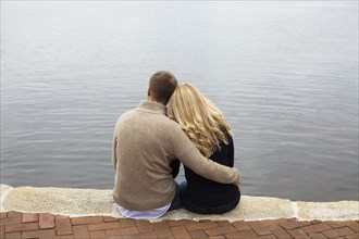 Caucasian couple hugging by lake