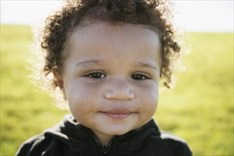 Close up of mixed race baby boy with curly hair
