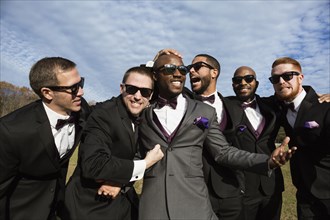 Groom and groomsmen posing for wedding pictures