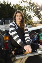 Woman sitting in truck bed