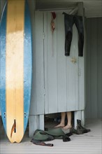Caucasian surfer changing in beach hut