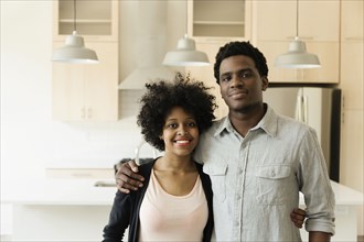 Couple hugging in kitchen in new house