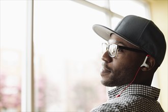 Black man listening to headphones indoors
