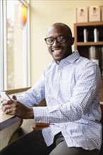 Black man using cell phone in coffee shop