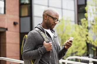 Black man using cell phone on city street
