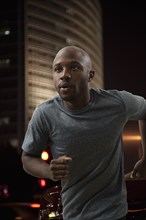 Black man running in city at night
