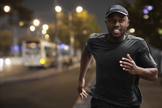 Black man running on city street at night